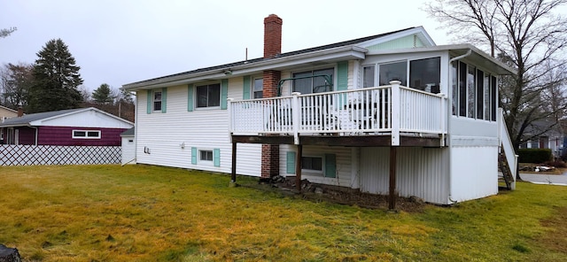 rear view of house with a sunroom, a lawn, and a chimney