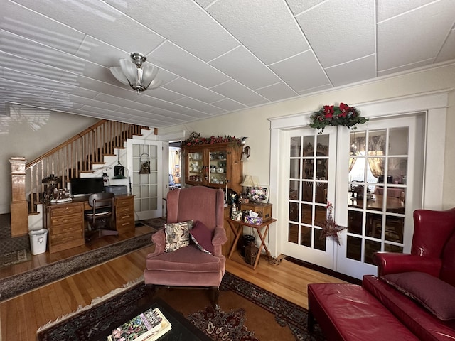 living area with stairs, wood finished floors, and french doors