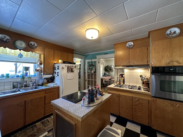 kitchen with a sink, stainless steel appliances, dark floors, and light countertops