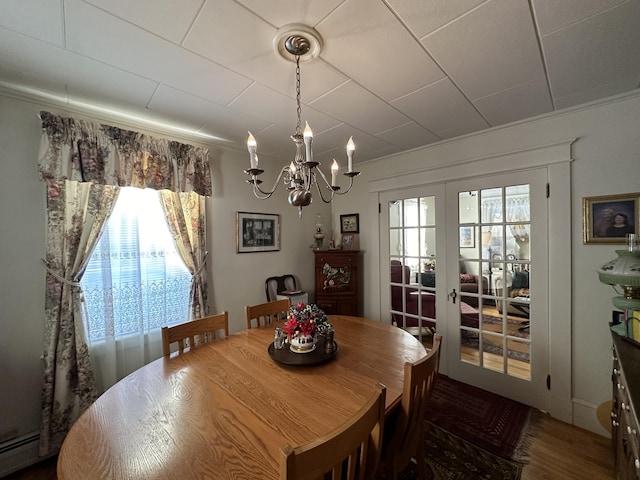 dining room featuring a baseboard radiator, french doors, and a notable chandelier