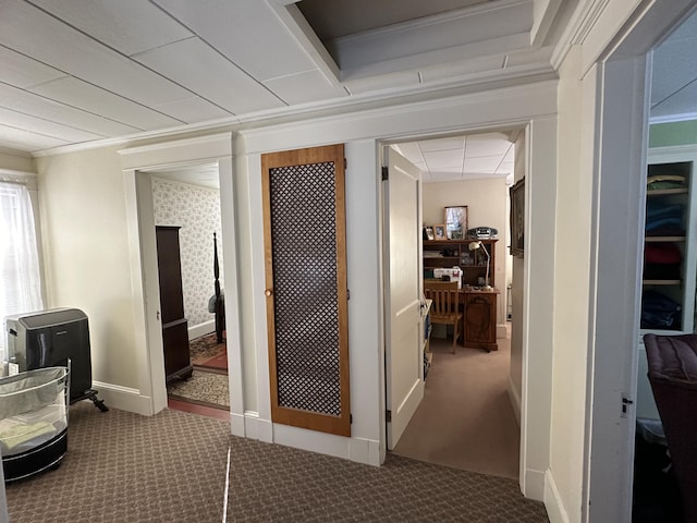 corridor with ornamental molding, carpet flooring, and baseboards