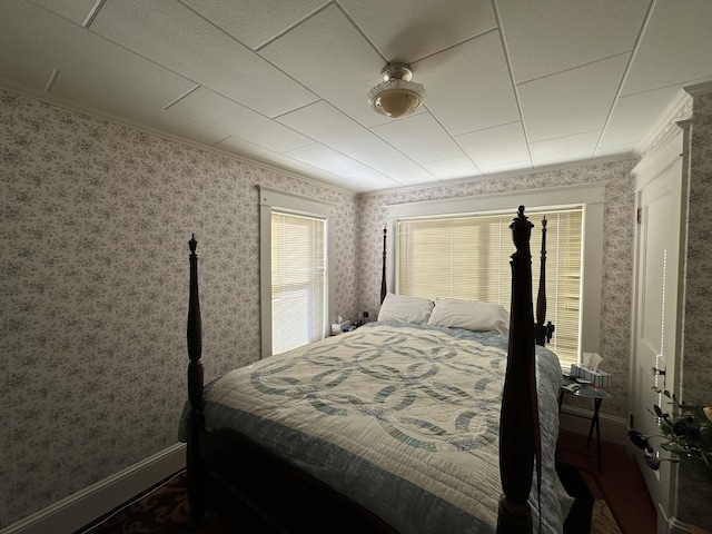 bedroom featuring crown molding, baseboards, and wallpapered walls