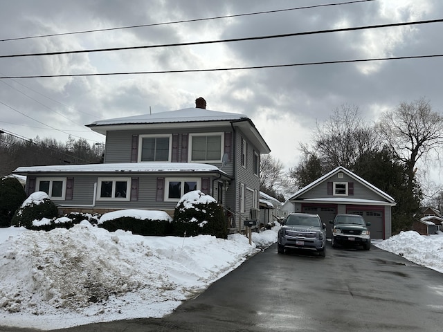 view of front of home with an outbuilding, a chimney, and a garage