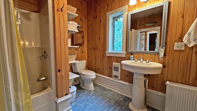 bathroom with toilet, wooden walls, a sink,  shower combination, and radiator heating unit