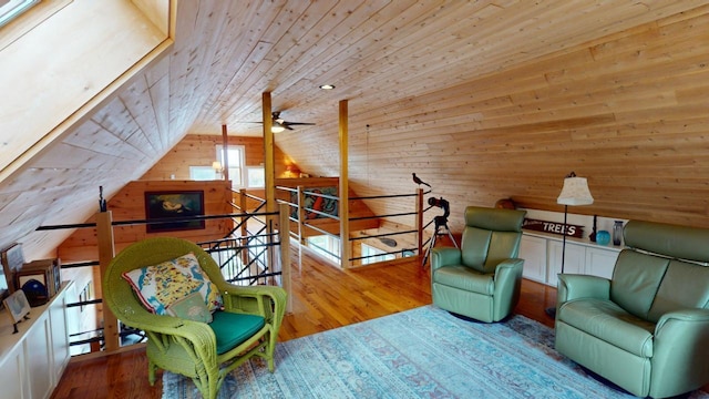 living area with lofted ceiling, wood walls, wood ceiling, an upstairs landing, and light wood-type flooring