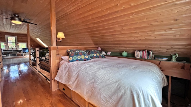 bedroom with lofted ceiling, wooden ceiling, wood finished floors, and wooden walls