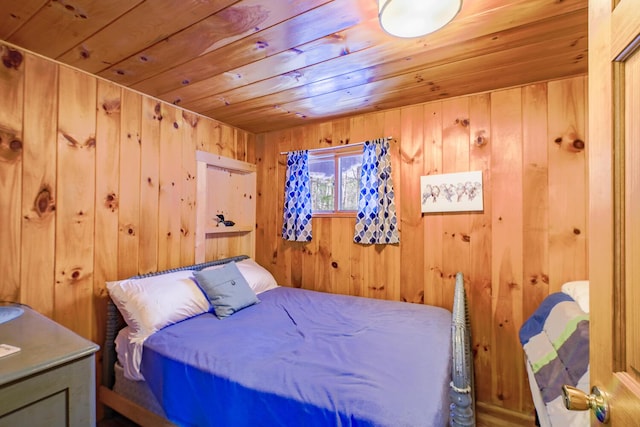 bedroom with wooden walls and wood ceiling