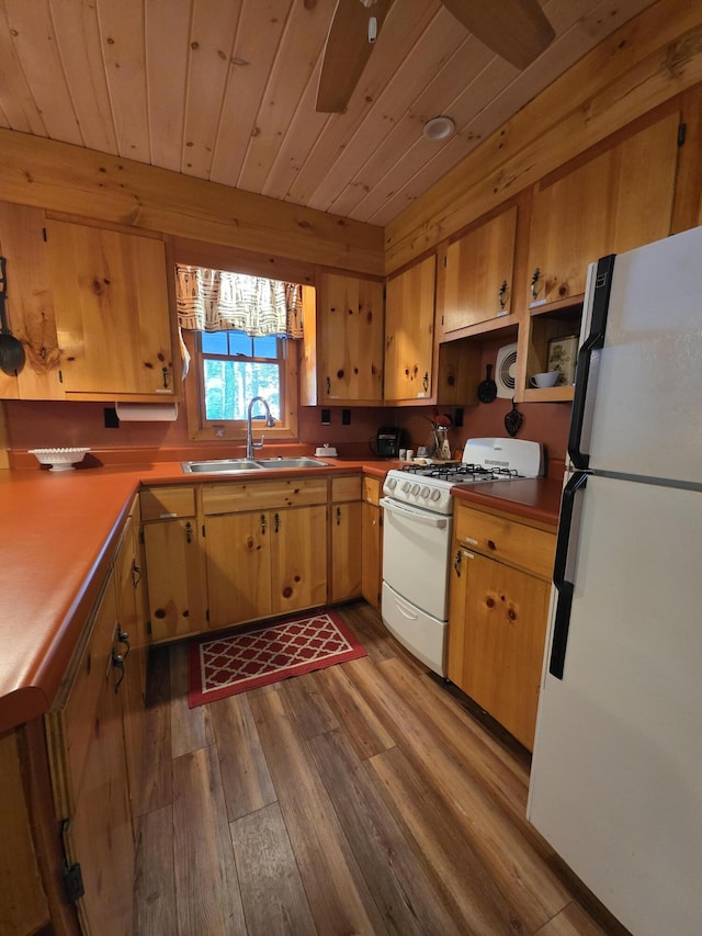 kitchen featuring white appliances, wood finished floors, wooden ceiling, and a sink