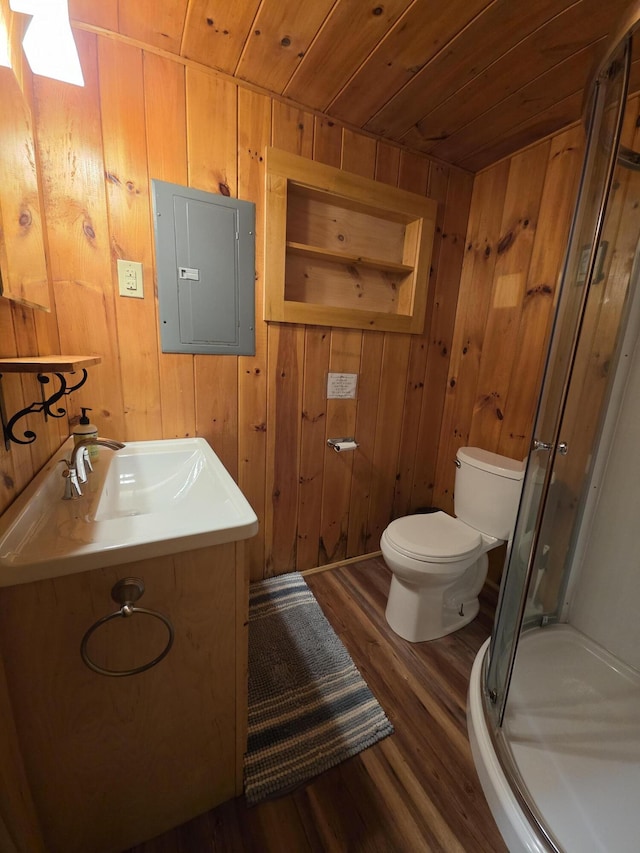 bathroom featuring toilet, electric panel, a stall shower, wooden ceiling, and wood finished floors