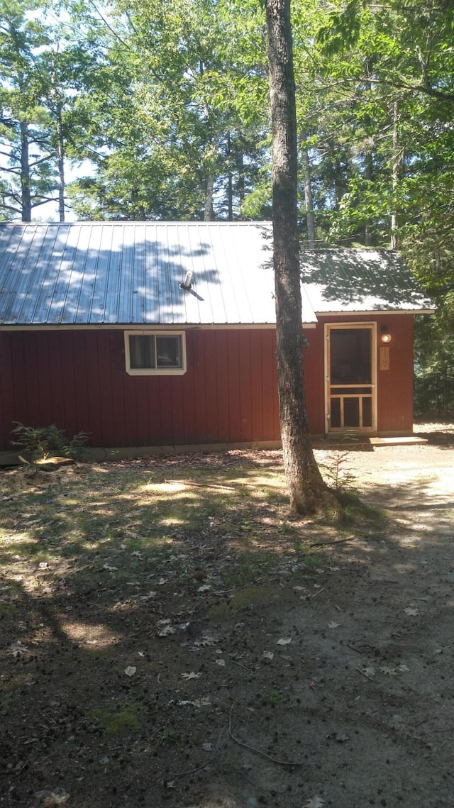 view of property exterior featuring an outbuilding and metal roof