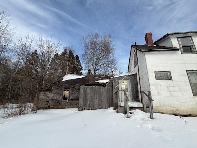 snow covered property with a chimney