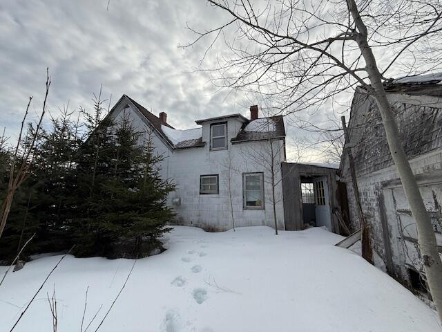 snow covered property featuring a chimney