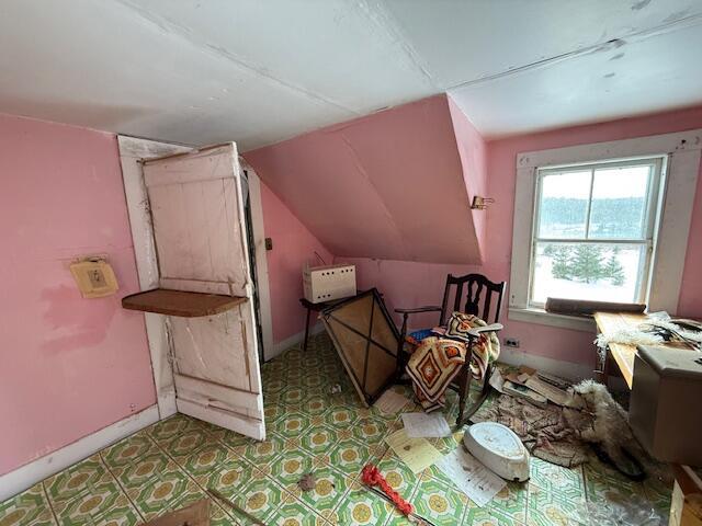 interior space with lofted ceiling and baseboards