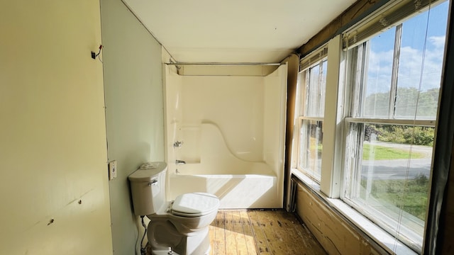 full bathroom featuring toilet, hardwood / wood-style flooring, and tub / shower combination