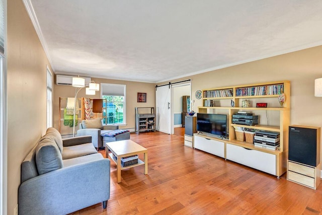 living area featuring a barn door, wood finished floors, and crown molding