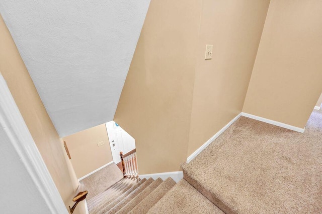 stairway featuring carpet and baseboards