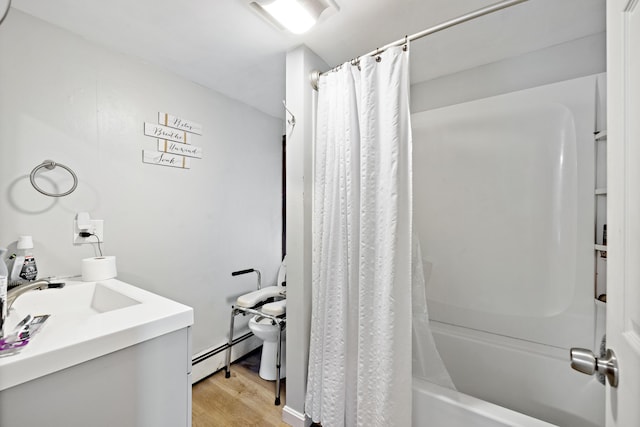 full bath with toilet, shower / tub combo with curtain, a sink, a baseboard heating unit, and wood finished floors