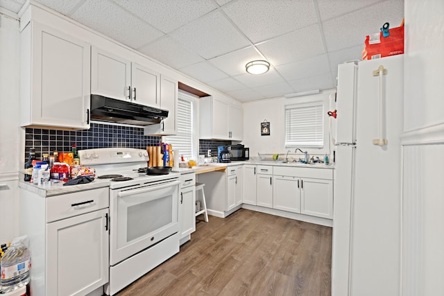 kitchen with under cabinet range hood, light countertops, light wood-style floors, white cabinets, and white appliances