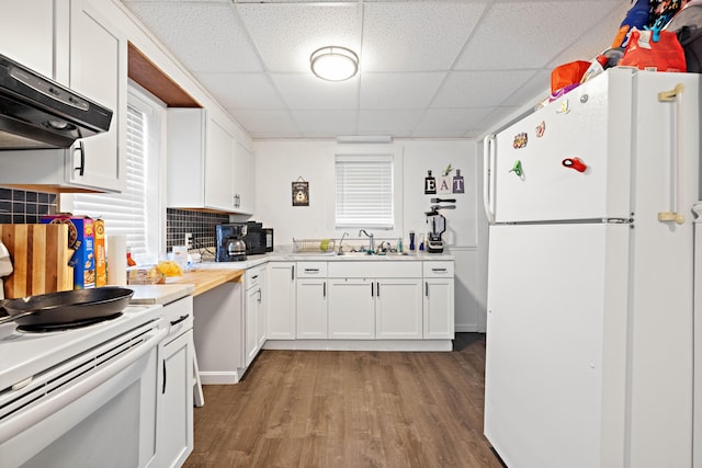 kitchen featuring light wood-style flooring, under cabinet range hood, white appliances, white cabinets, and light countertops