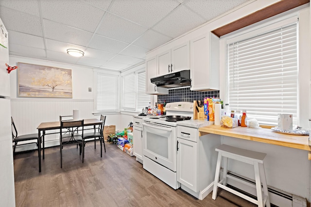 kitchen featuring light wood-type flooring, under cabinet range hood, a baseboard heating unit, white electric range oven, and white cabinets