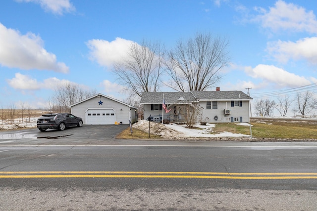 view of front of house with a garage, an outbuilding, roof with shingles, and a chimney