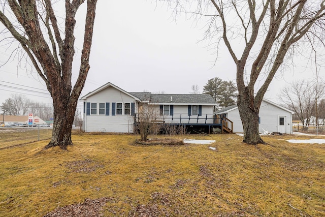 view of front of property with a deck, a front yard, and fence