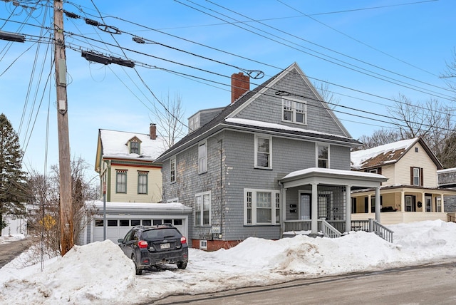 view of front of property featuring a garage, a chimney, and a porch