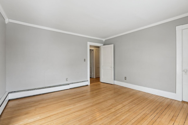 spare room with baseboard heating, crown molding, light wood-style flooring, and baseboards