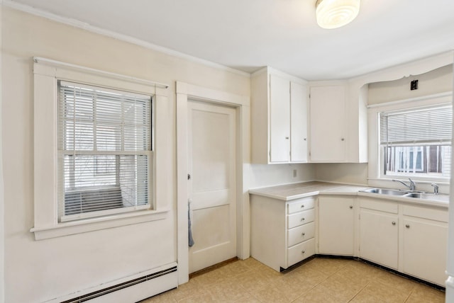 kitchen with a baseboard heating unit, light countertops, a sink, and white cabinetry