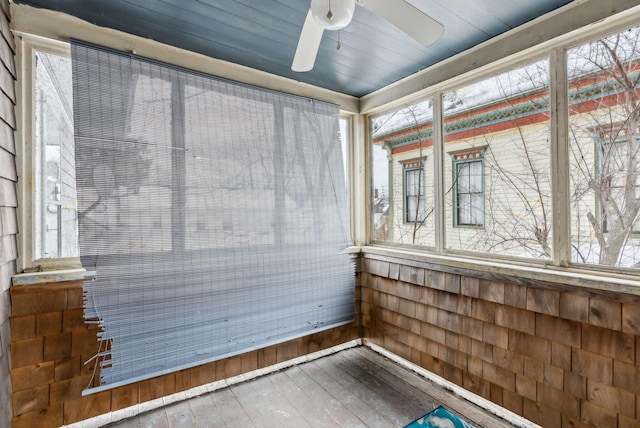 unfurnished sunroom featuring a ceiling fan