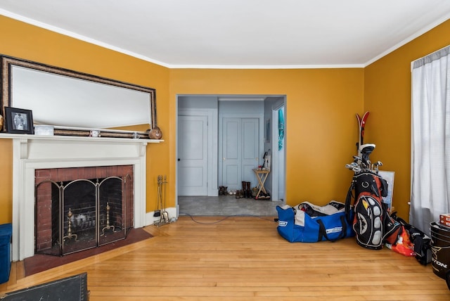 living room with light wood-style floors, a fireplace, and ornamental molding