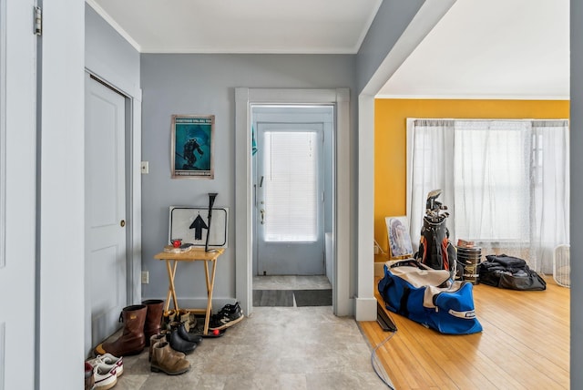 entryway featuring ornamental molding and light wood-style floors