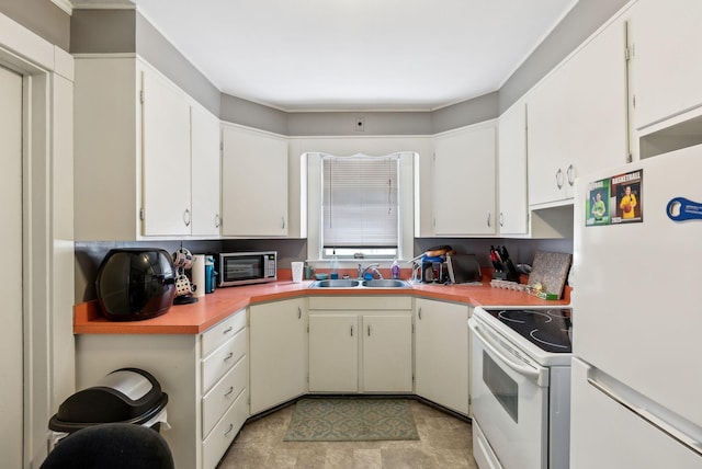 kitchen with a toaster, white appliances, a sink, white cabinets, and light countertops