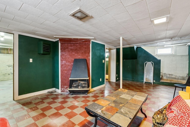 below grade area featuring a fireplace, baseboards, and tile patterned floors