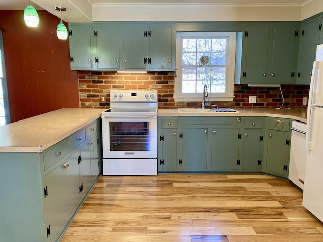 kitchen with electric range, hanging light fixtures, a peninsula, light countertops, and a sink