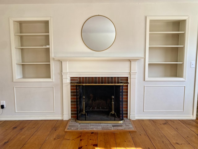 room details featuring a fireplace, built in features, and wood finished floors