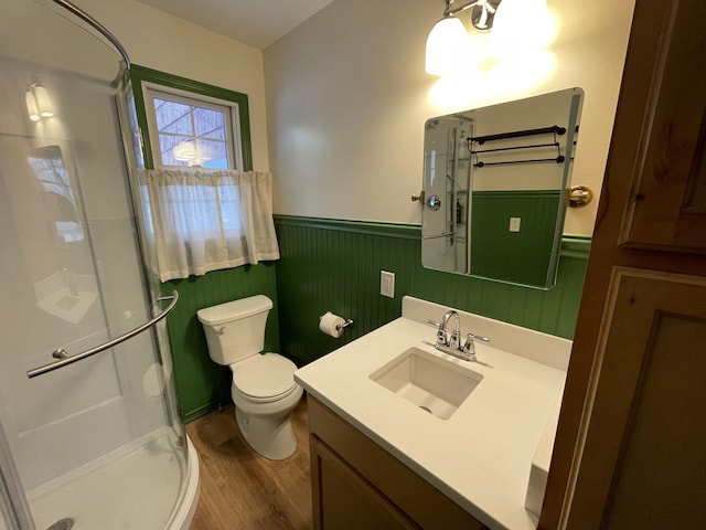 full bathroom with toilet, a wainscoted wall, a shower stall, and vanity