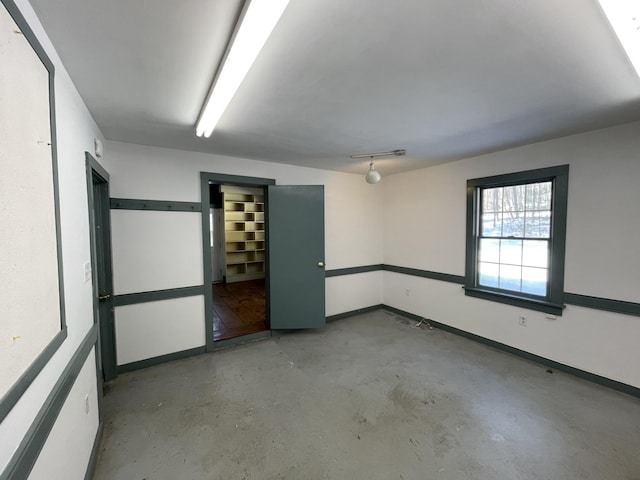 empty room featuring concrete flooring and baseboards