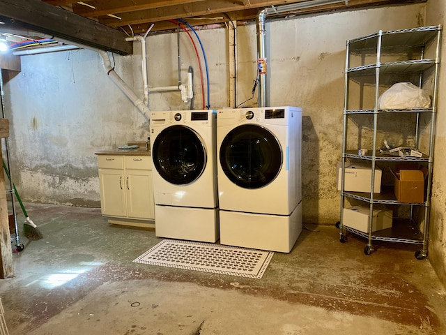 washroom featuring washing machine and clothes dryer and cabinet space