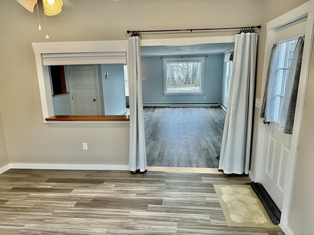 spare room with baseboards and wood finished floors