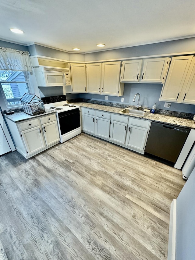 kitchen featuring light wood-type flooring, white appliances, a sink, and recessed lighting