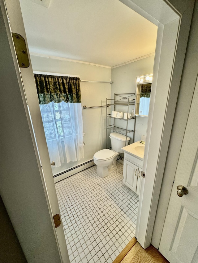 half bath with tile patterned flooring, toilet, vanity, ornamental molding, and baseboard heating