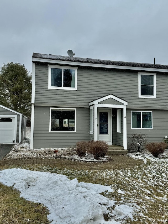 colonial home with a garage and an outbuilding