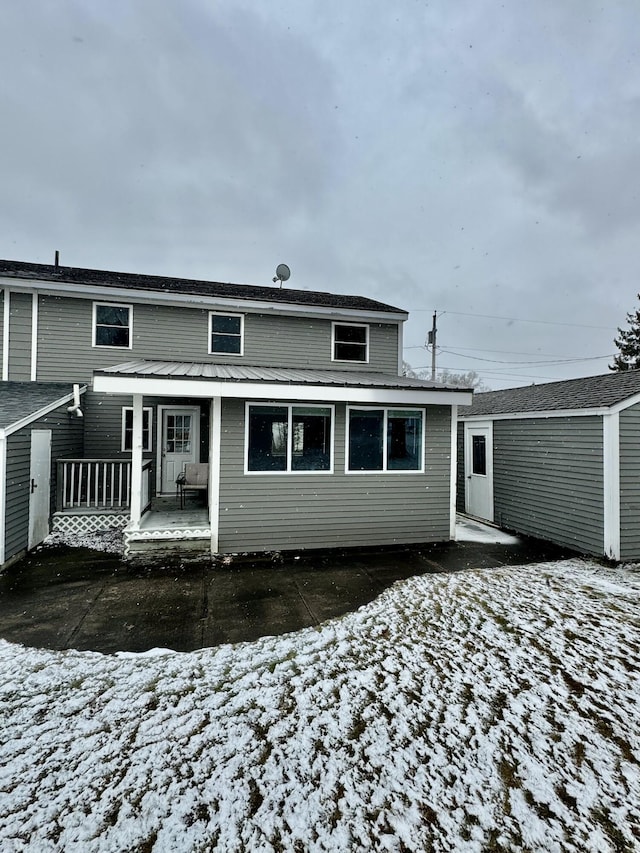 view of snow covered rear of property