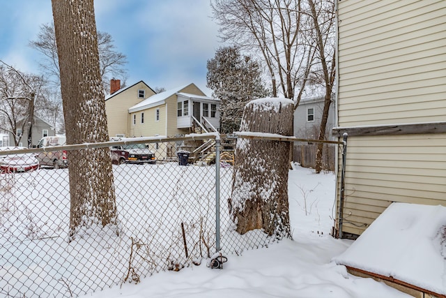 snowy yard featuring fence