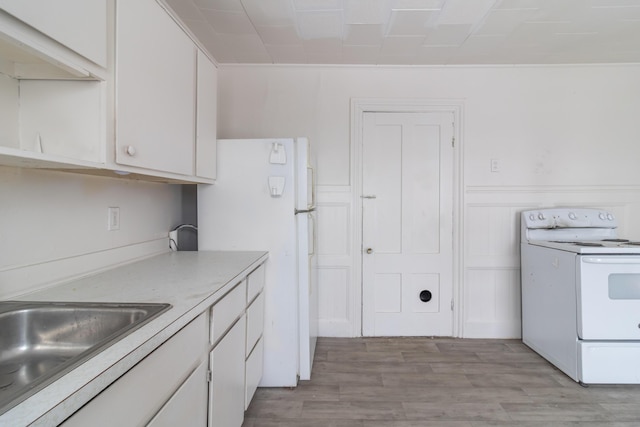 kitchen featuring a sink, white appliances, white cabinets, and light countertops