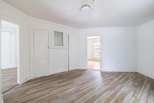 unfurnished bedroom featuring light wood-type flooring and baseboards