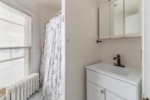 bathroom featuring curtained shower, radiator heating unit, and vanity