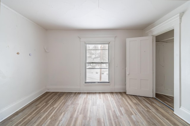 unfurnished bedroom featuring light wood-style flooring and baseboards