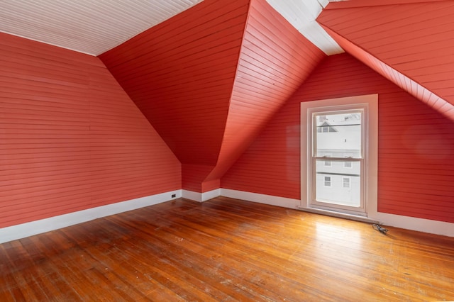 bonus room with vaulted ceiling, wood finished floors, and baseboards